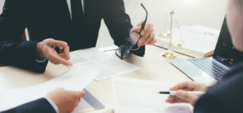 A group of people sitting around a table discussing legal matters
